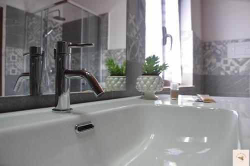 Capri Leone的住宿－Gli zii di Sicilia - casa vacanze，浴室水槽设有水龙头和镜子
