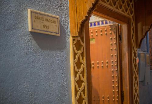 a mirror next to a door with a sign on a wall at Riad Haddaji Fes in Fez