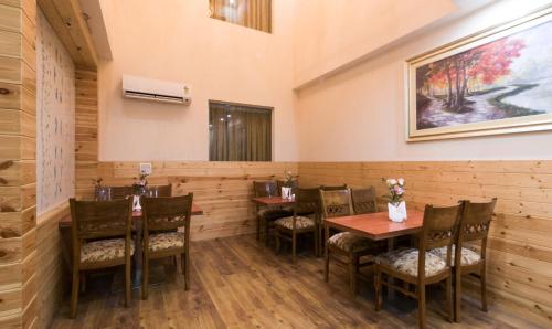 a dining room with wooden tables and chairs at Treebo House Inn in Noida