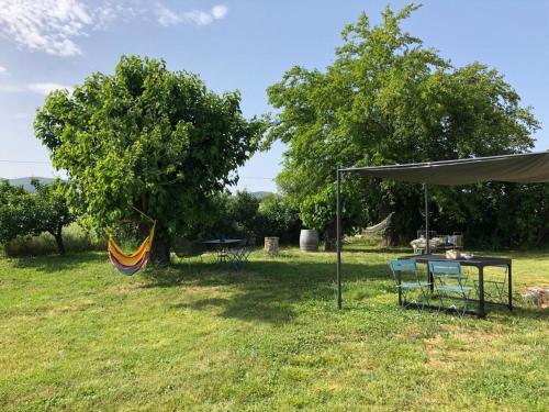 uma tenda e uma rede num campo em Gîte à 10 minutes d'Anduze, au pied des Cévennes em Bagard