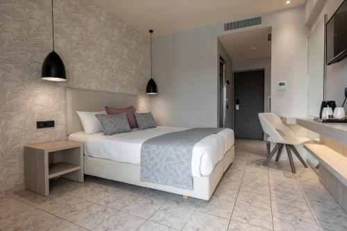a bedroom with a white bed and a kitchen at Zante Sun Resort in Lithakia