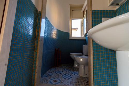a bathroom with a sink and a toilet at Locanda Popolare in Aci Castello