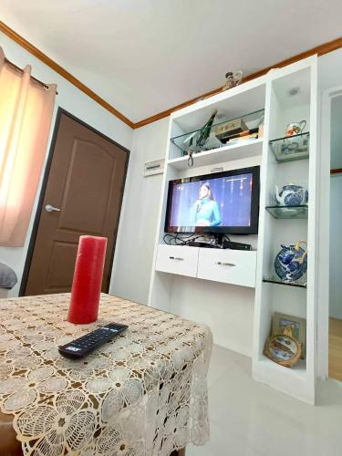 a living room with a table and a television in a cabinet at Davao 2br One Oasis Beside SM Mall-Wifi in Davao City