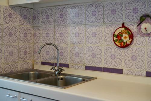 een keuken met een wastafel en een bord aan de muur bij Two bedrooms Capri style home near Piazzetta in Capri