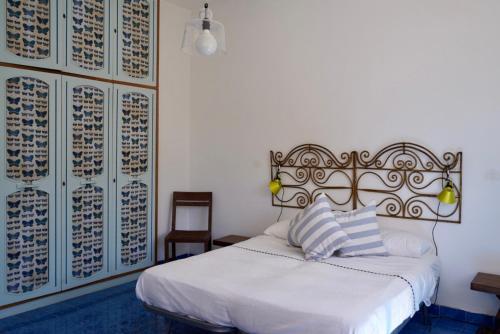 1 dormitorio con 1 cama blanca y 1 silla en Two bedrooms Capri style home near Piazzetta, en Capri