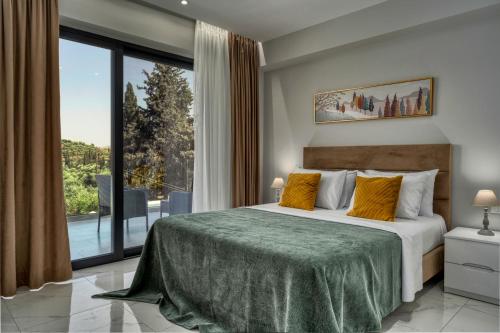 a bedroom with a bed and a large window at Johnny's White Luxury Villa in Tsilivi