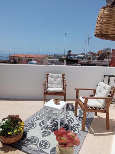 a patio with two chairs and a coffee table and a table at B&B Giallolumia in Portopalo
