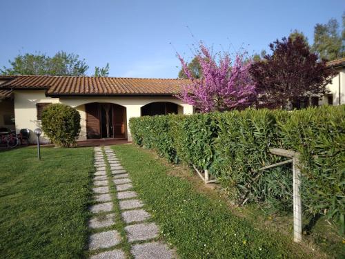 um jardim com um caminho de pedra em frente a uma casa em Residence LA CANOVA em Marina di Grosseto