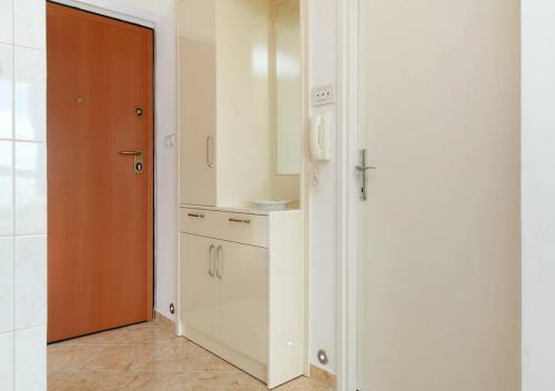 a kitchen with white cabinets and a brown door at Apartment 28 in Split