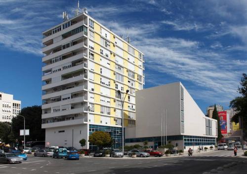 a tall white building in a city with a parking lot at Apartment 28 in Split