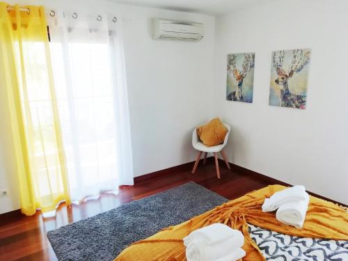 a bedroom with a bed and a chair in it at Sunny Retreat in Luz