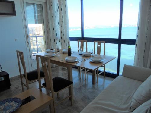 a dining room table and chairs with a view of the ocean at Apartamento Azul Marino by Rental Olé in San Blas