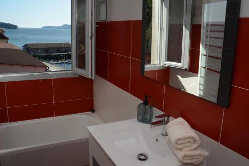 a bathroom with a sink and a tub and a mirror at Desconectaenlasriasbaixas Campelo playa in Poio