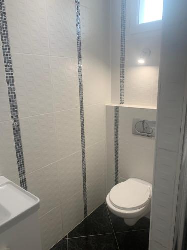 ein Badezimmer mit einem WC und einer Glasduschkabine in der Unterkunft Villa Tenjin chambre 7 in Bondy