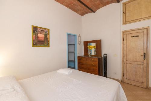 宛圖里那的住宿－Casetta Max - Venturina Terme，卧室配有白色的床和木门