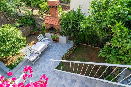 un patio con 2 sillas, chimenea y flores en Apartment Matej, en Dubrovnik