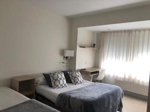 a hotel room with a bed and a window at Pensión Cantabrico in Navia