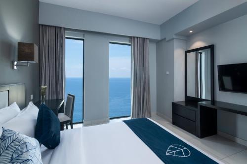 a bedroom with a large bed and a large window at MaRadha Colombo in Colombo