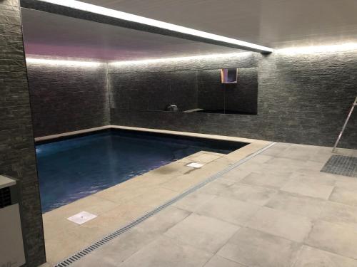 a swimming pool in a room with a tile floor at Black Diamond Sainte Foy Chalets in Sainte-Foy-Tarentaise