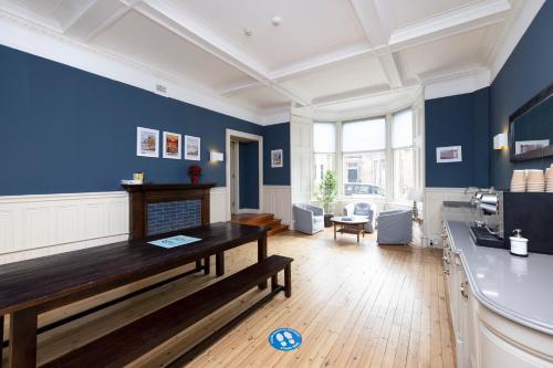 a large living room with blue walls and a bench at JOIVY Haymarket in Edinburgh