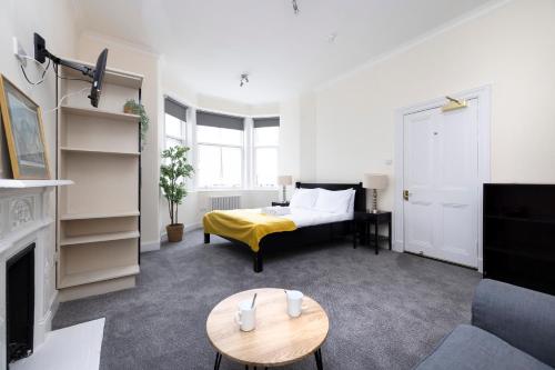 a living room with a bed and a table at JOIVY Haymarket in Edinburgh