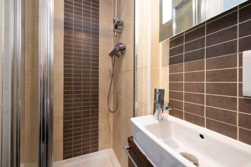 a bathroom with a shower and a sink at JOIVY Haymarket in Edinburgh