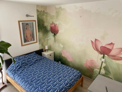 - une chambre avec un lit et des fleurs peintes sur le mur dans l'établissement Parenthèse à Sète, à Sète