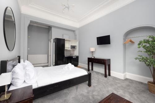 a bedroom with a bed and a table and a mirror at JOIVY Haymarket in Edinburgh