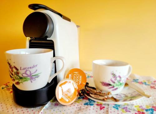 two cups on a table next to a coffee maker at THINK POSITIVE ;) in Juodkrantė