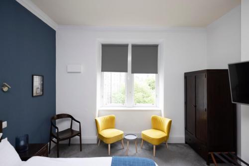 a bedroom with two chairs and a table and a window at JOIVY Haymarket in Edinburgh