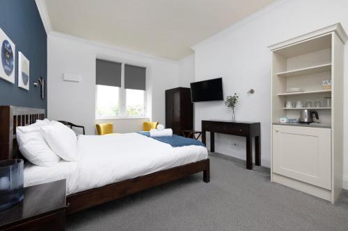 a bedroom with a bed and a desk and a computer at JOIVY Haymarket in Edinburgh