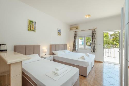 two beds in a room with a balcony at Apartments Bonaca in Igalo