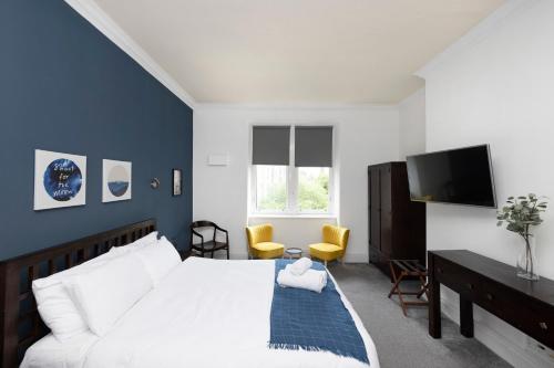 a bedroom with a white bed and a tv at JOIVY Haymarket in Edinburgh