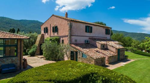 a large stone house with a green yard at Country Relais La Mortella in Porto Ercole