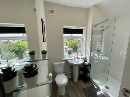 a bathroom with a toilet and a sink and a shower at Western House - By Sigma Stays in Crewe