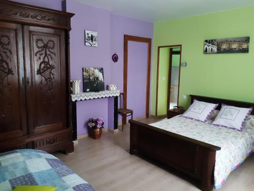 um quarto com uma cama com paredes roxas e verdes em AU COEUR DE L'ENCLAVE em Moeuvres