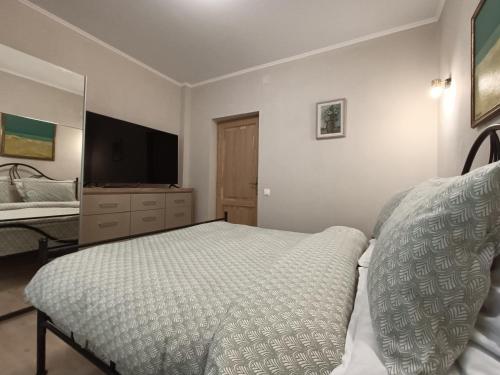a bedroom with a bed and a dresser with a television at ElStefanino House in Eforie Nord