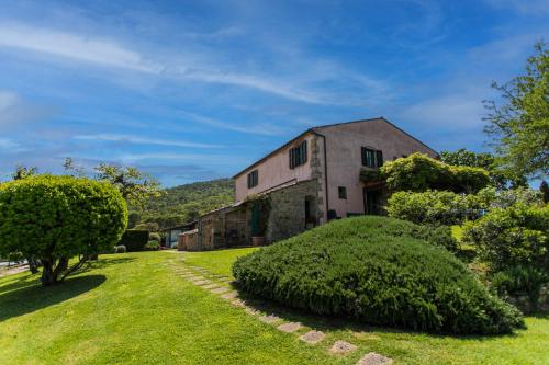 an old stone house with a green yard at Country Relais La Mortella in Porto Ercole