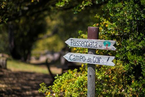 a sign for a park with two street signs at Country Relais La Mortella in Porto Ercole