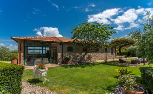 a house with a yard with a lawn at Country Relais La Mortella in Porto Ercole
