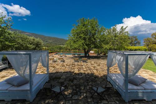 a patio with a bed and a pool at Country Relais La Mortella in Porto Ercole