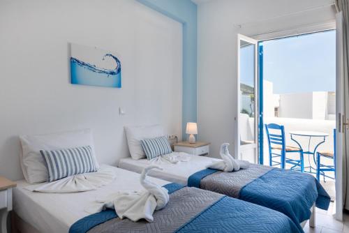 two beds in a room with a view of the ocean at Ayeri Hotel in Parikia