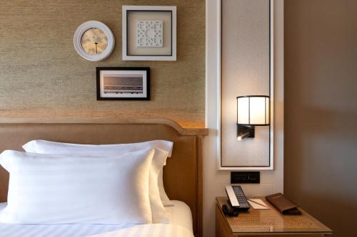 a hotel room with a bed and a clock on the wall at Dusit Thani Hua Hin in Cha Am