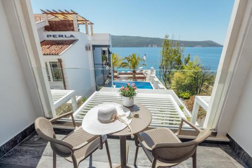a balcony with a table and chairs and a view of the ocean at Hotel Perla in Herceg-Novi