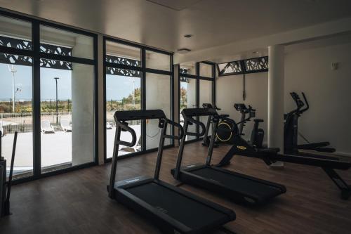 a gym with two tread machines in a room with windows at Belambra Clubs Port Camargue - Les Salins in Le Grau-du-Roi