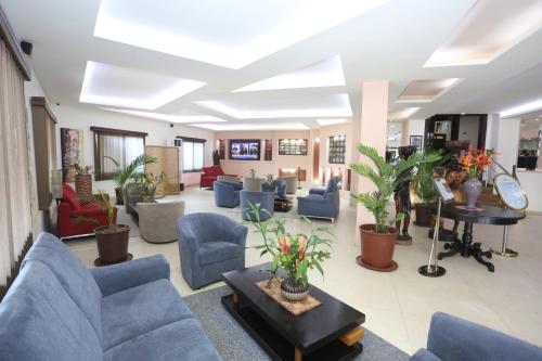 a lobby with couches and chairs and plants at The Cape Hotel in Monrovia