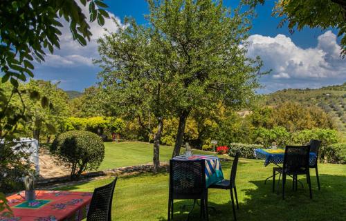 a table and chairs in a garden with a table at Country Relais La Mortella in Porto Ercole