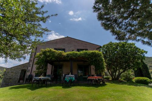 a house with tables and chairs in the yard at Country Relais La Mortella in Porto Ercole