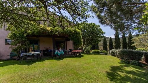 a yard with tables and chairs in front of a house at Country Relais La Mortella in Porto Ercole