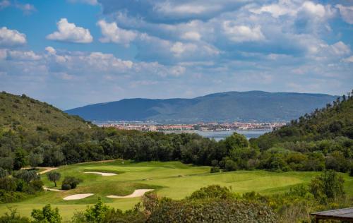 a golf course with a view of the lake and mountains at Country Relais La Mortella in Porto Ercole